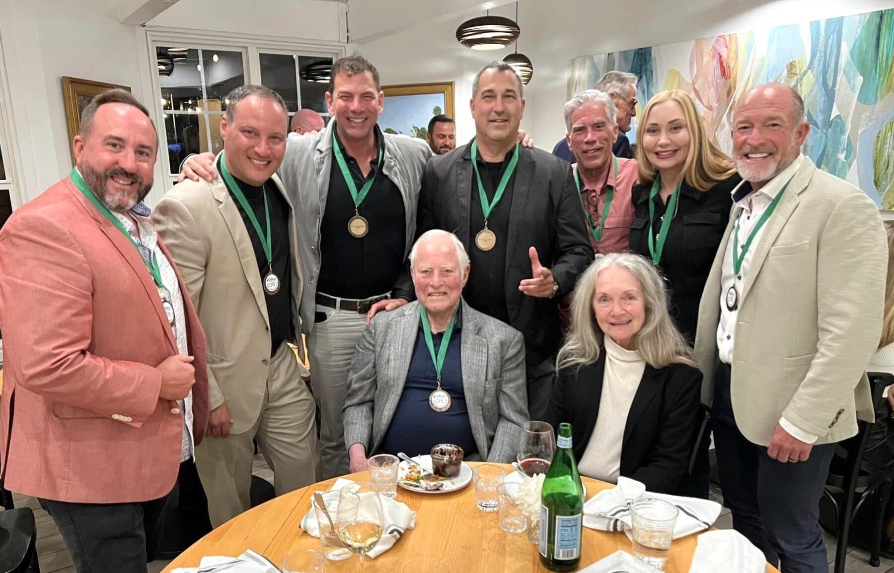 Jim Cathcart surrounded by CPE holders wearing their medallions at the Summit dinner